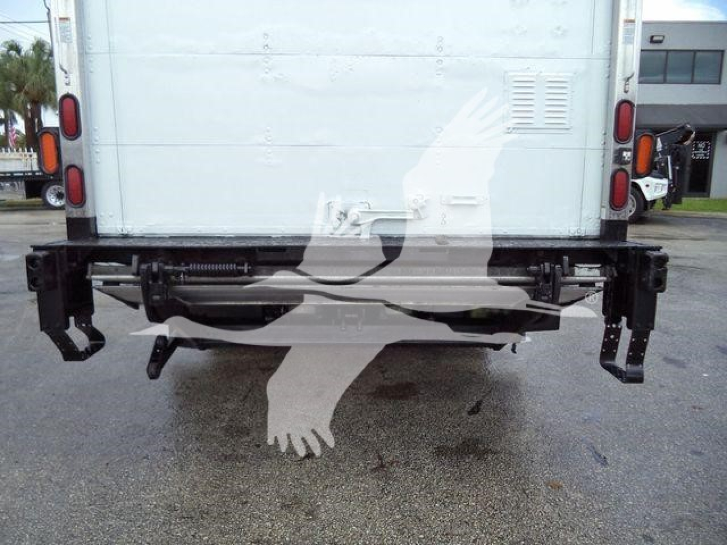 Rear view of a 2015 Isuzu NPR-HD box truck showing rear bumper, hitch, and taillights with stock number text not visible.