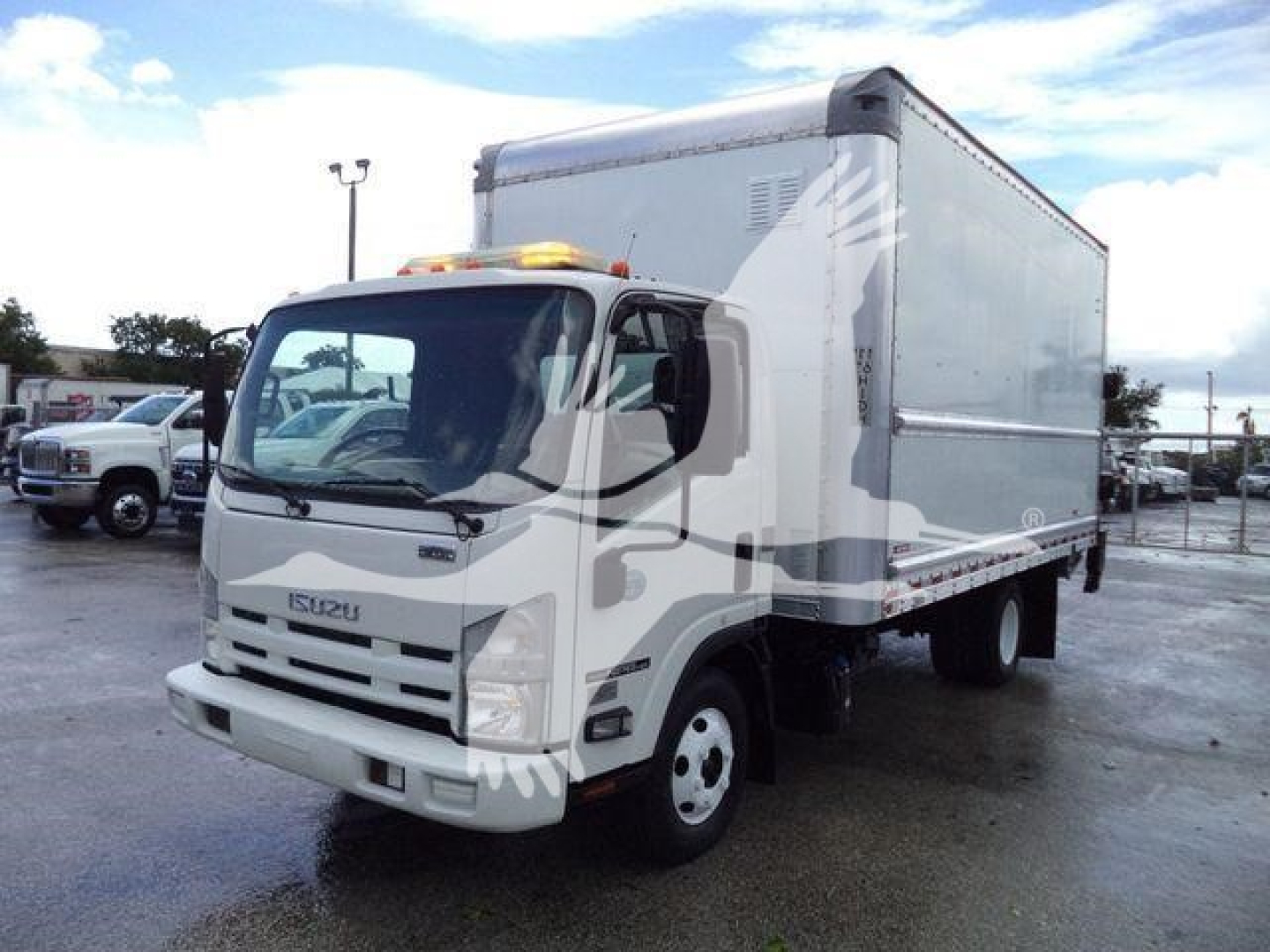 Isuzu NPR HD box truck in side view showing cab and box with amber warning light on cab roof