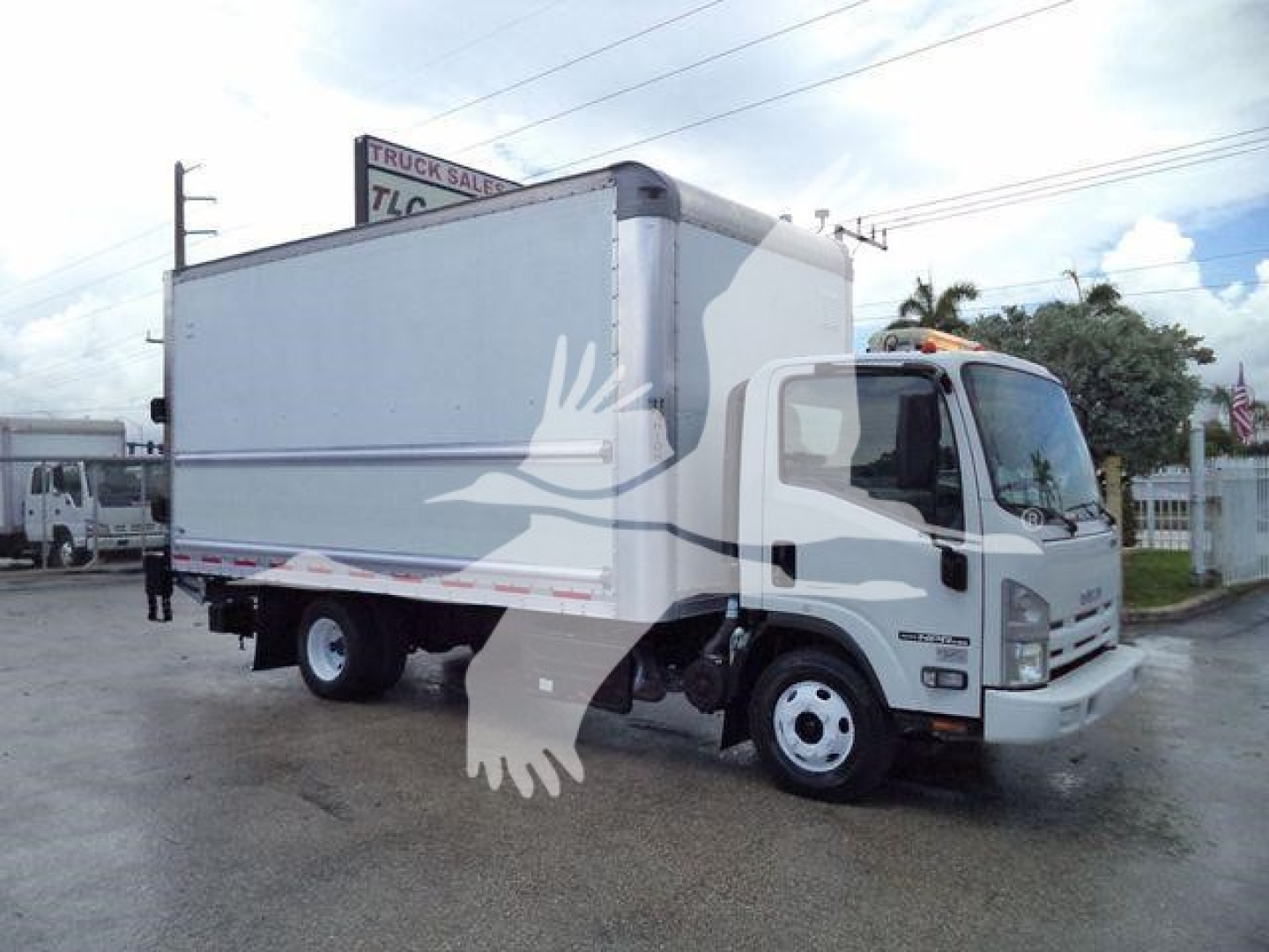 Isuzu NPR HD box truck in side view showing cargo box and cab, street scene, dealership lot