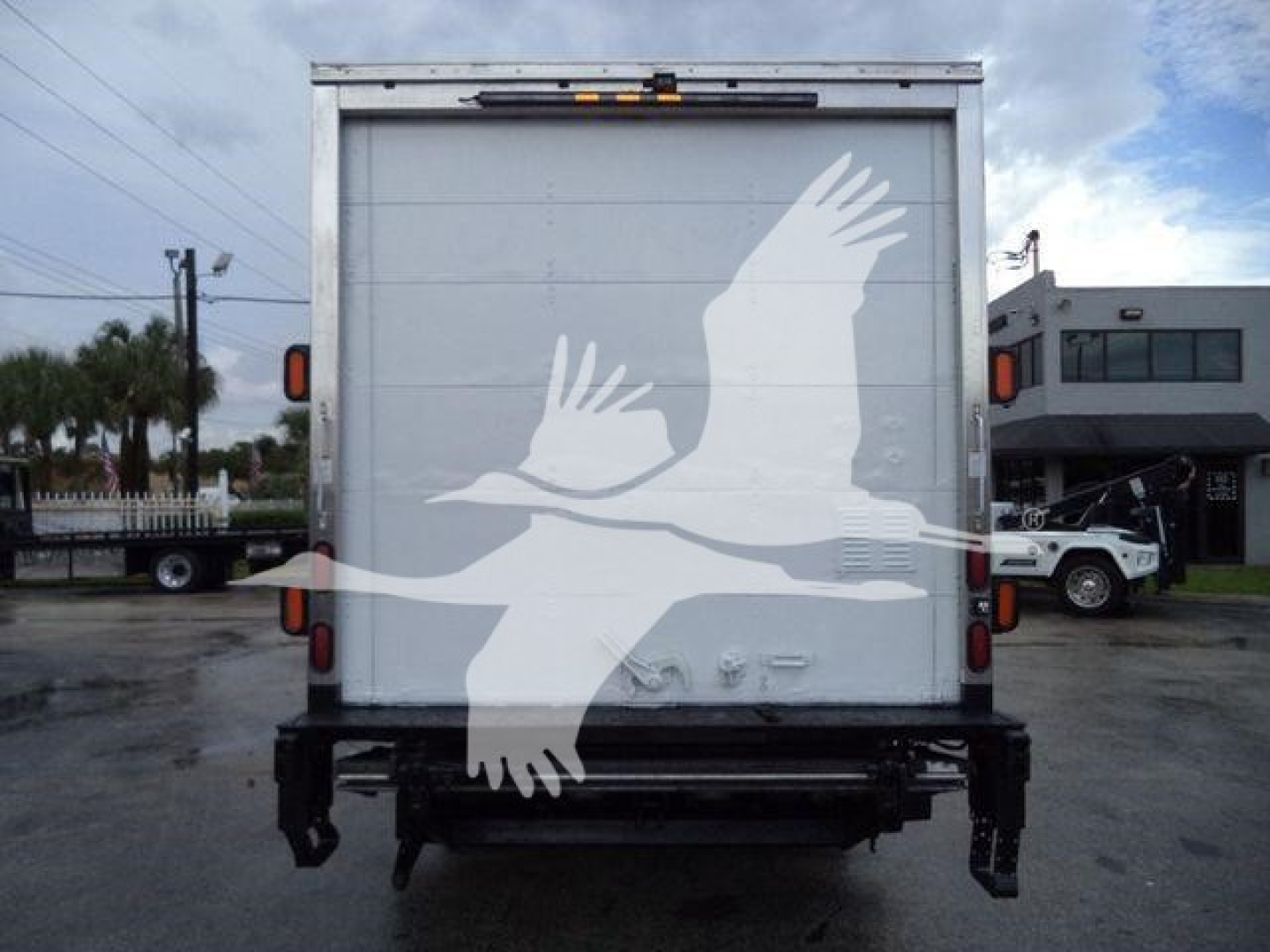 Isuzu NPR HD box truck rear showing doors and bumper with tail lights.