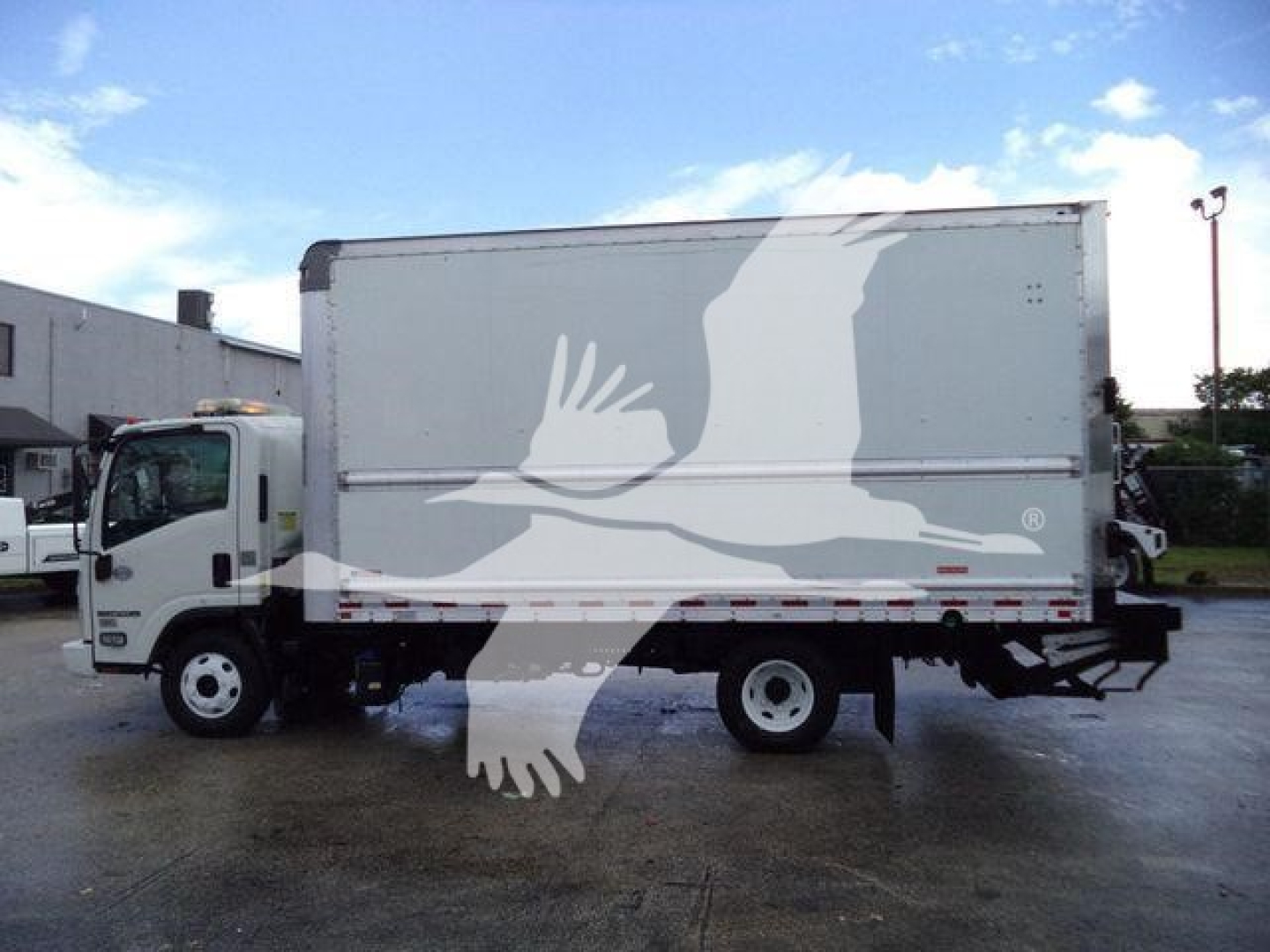 Isuzu NPR HD box truck side view with stock number T05048FM and white cargo box.
