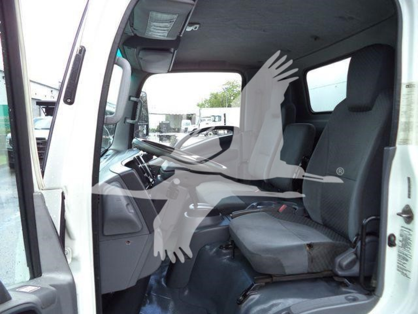 Isuzu NPR HD truck cabin interior showing driver seat and dashboard from open door