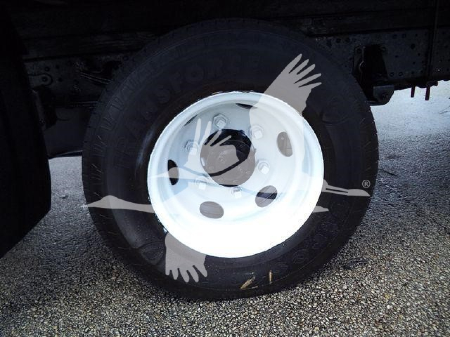 Isuzu NPR HD chassis showing front wheel with white steel wheel and tire sidewall text