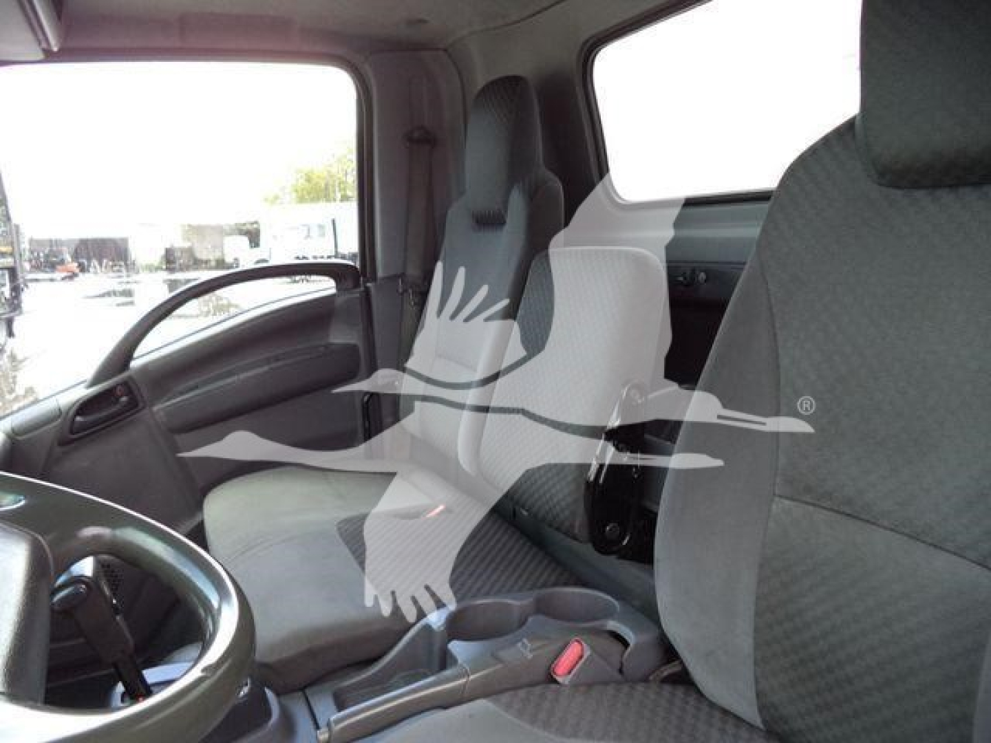Isuzu NPR-HD truck interior showing driver and passenger seats with steering wheel and dashboard visible