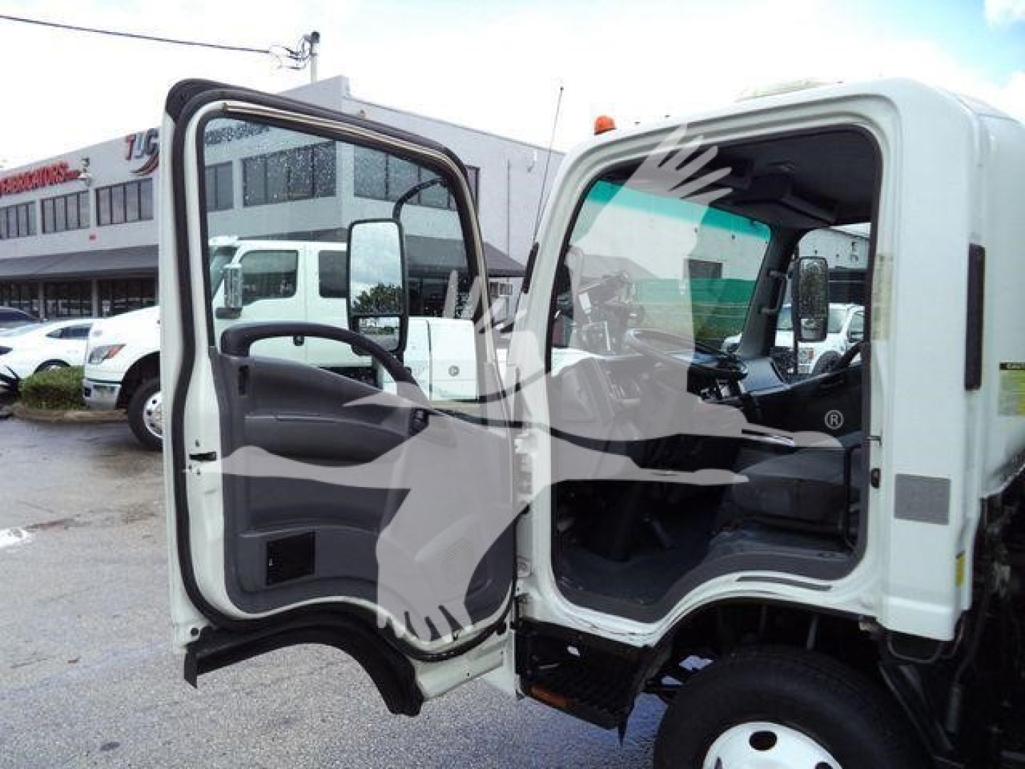 Isuzu NPR HD truck cab with both doors open, showing interior dashboard and steering wheel.