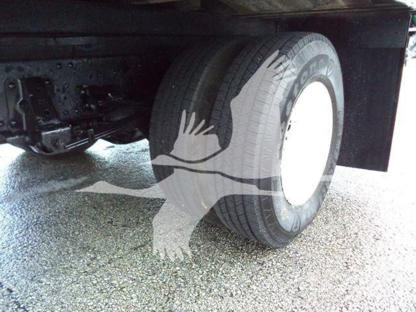 Isuzu NPR HD truck rear wheel and suspension visible under the cargo box.
