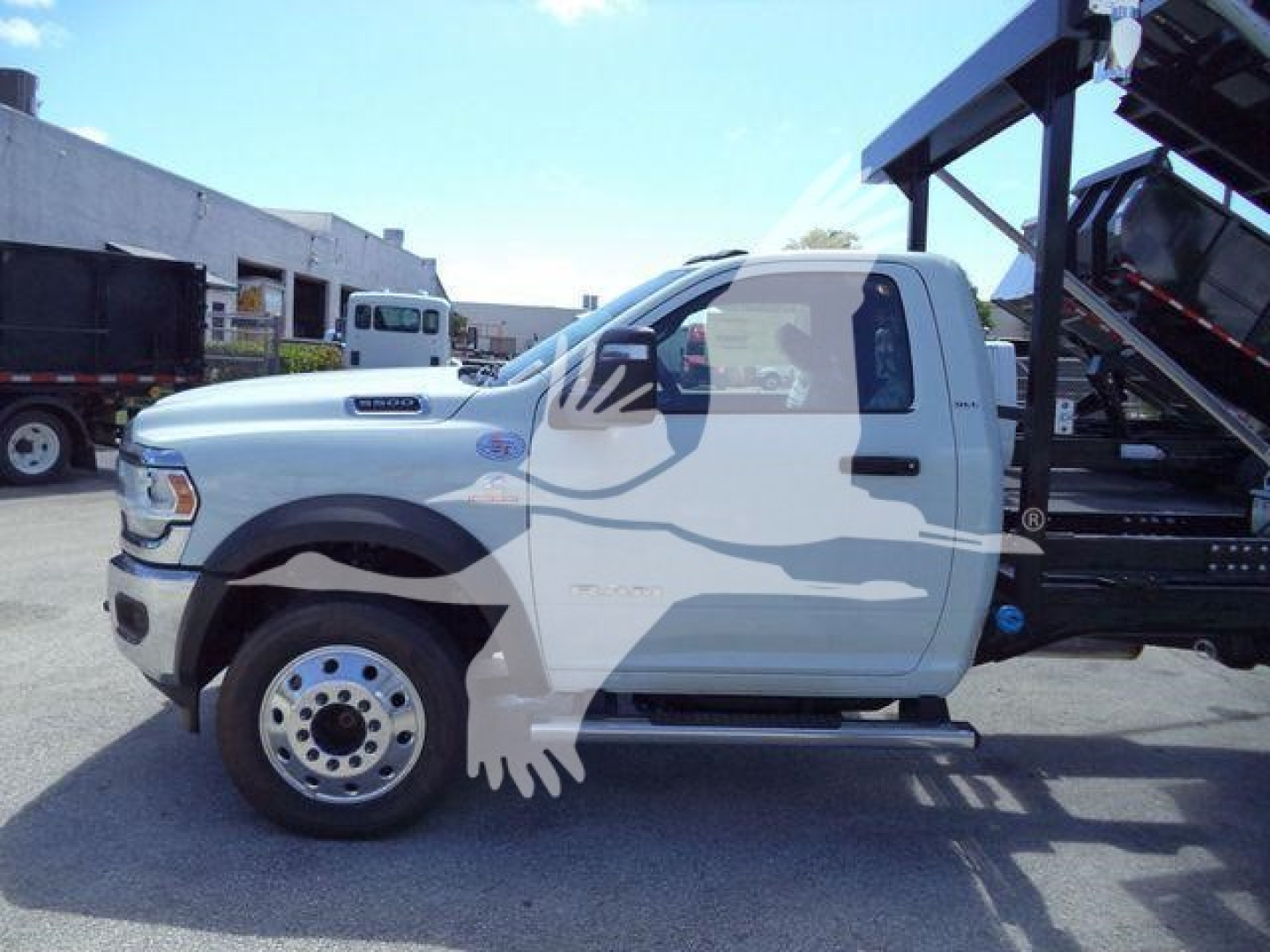 Ram 5500 cab with roll-off bed side view showing front door, wheel and step. Text on side includes Ram 5500 badge and Ram grille emblem.