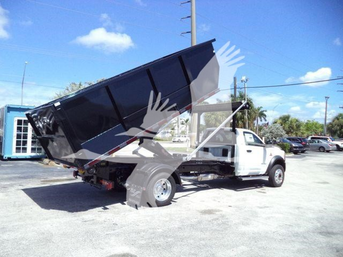 Ram 5500 dump truck in-service view with black dump bed raised, white cab, stock number DSL550014SNG4X4 visible in listing context.