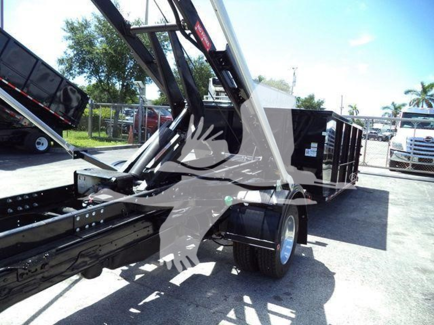 Ram 5500 dump truck or roll-off body showing hydraulic lifting arm and chassis frame.