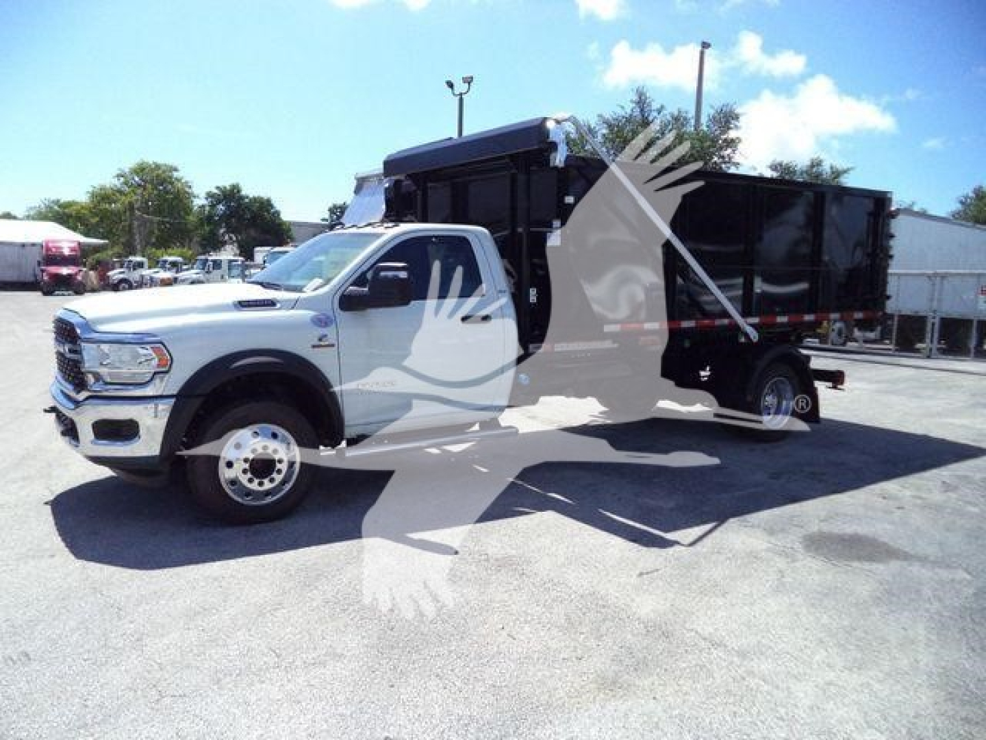 Ram 5500 HD SLT dump truck with black dump bed in a dealership lot.