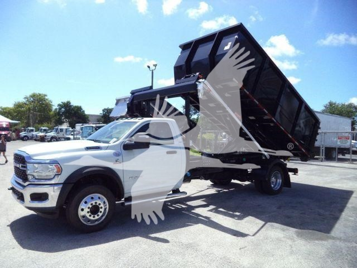 Ram 5500 HD SLT dump truck with raised dump bed in a dealership lot.