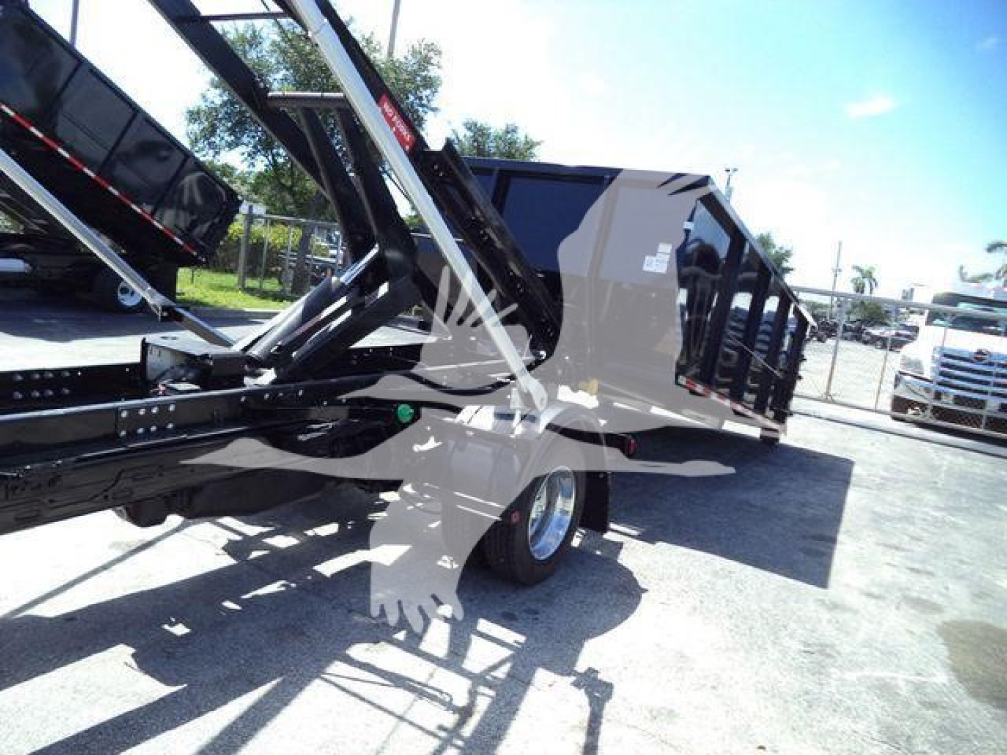 Ram 5500 HD SLT roll-off truck chassis and dump body with hydraulic arms and black paint.