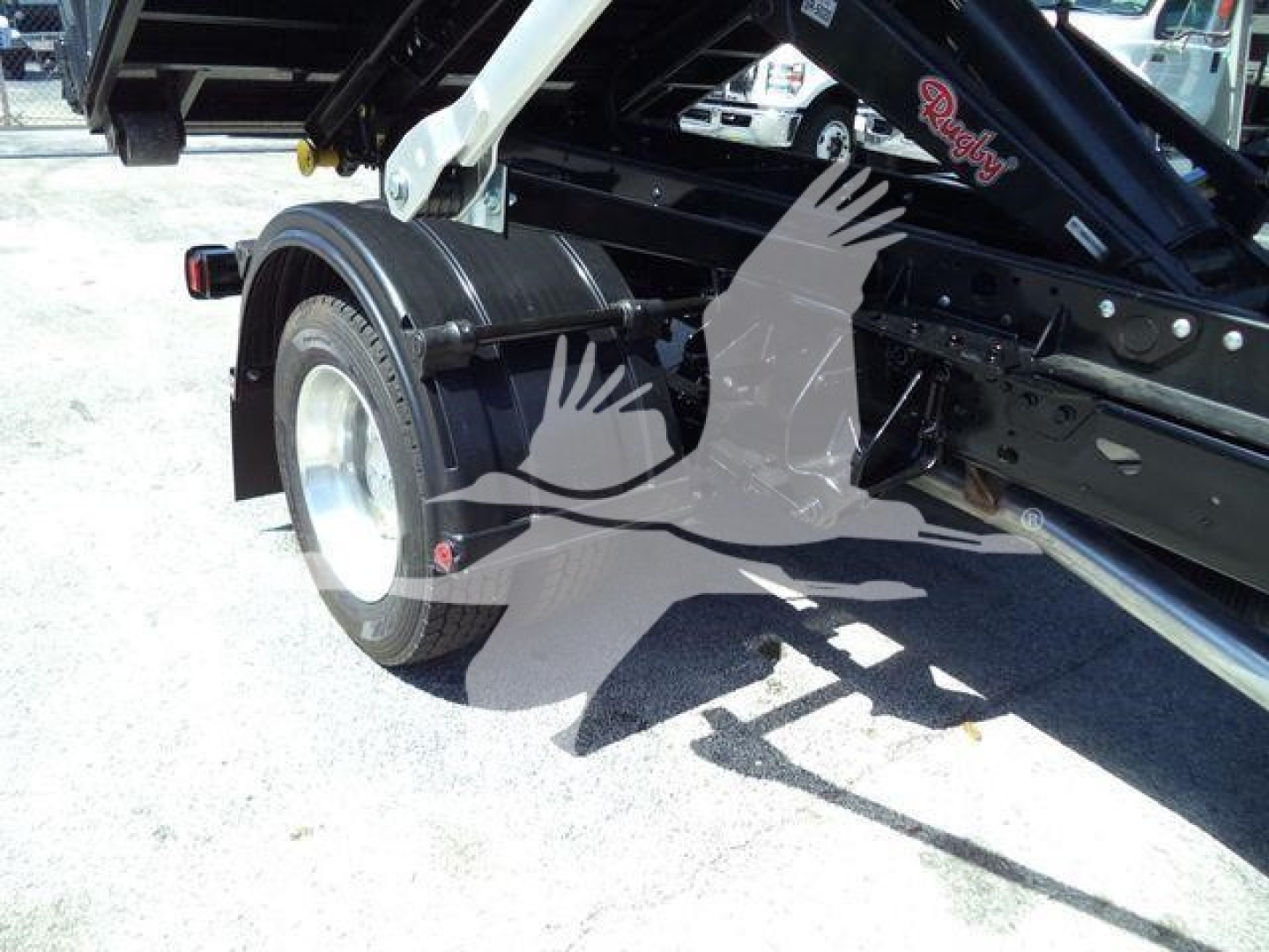Ram 5500 HD SLT roll-off truck chassis and rear wheel area with hydraulic lift arm components visible.