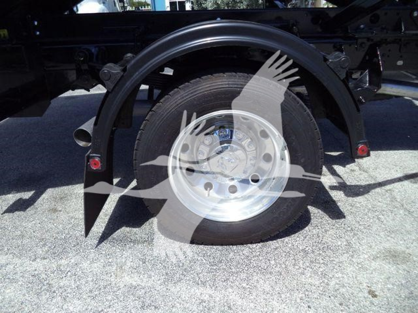 Ram 5500 dual rear wheel hub showing wheel and fender, with partial undercarriage components visible.