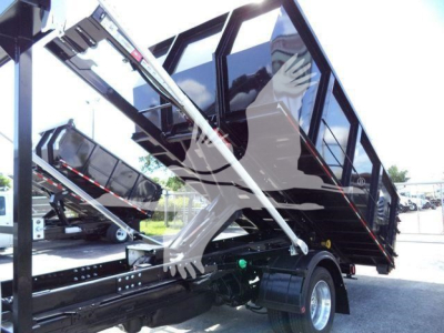 Ram 5500 dump bed / roll-off truck chassis with hydraulic arms and black cab visible.