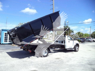 Ram 5500 dump truck in-service view with black dump bed raised, white cab, stock number DSL550014SNG4X4 visible in listing context.