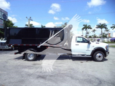 Ram 5500 dump truck in service view showing white cab and black dump body with extended wheelbase.