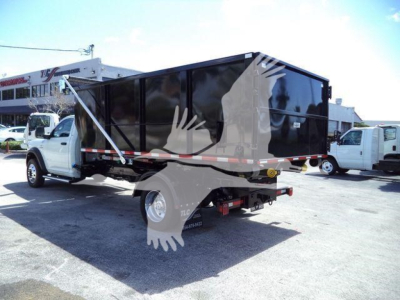 Ram 5500 dump truck with a black dump box and white cab, side view showing dual rear wheels and long cargo bed.