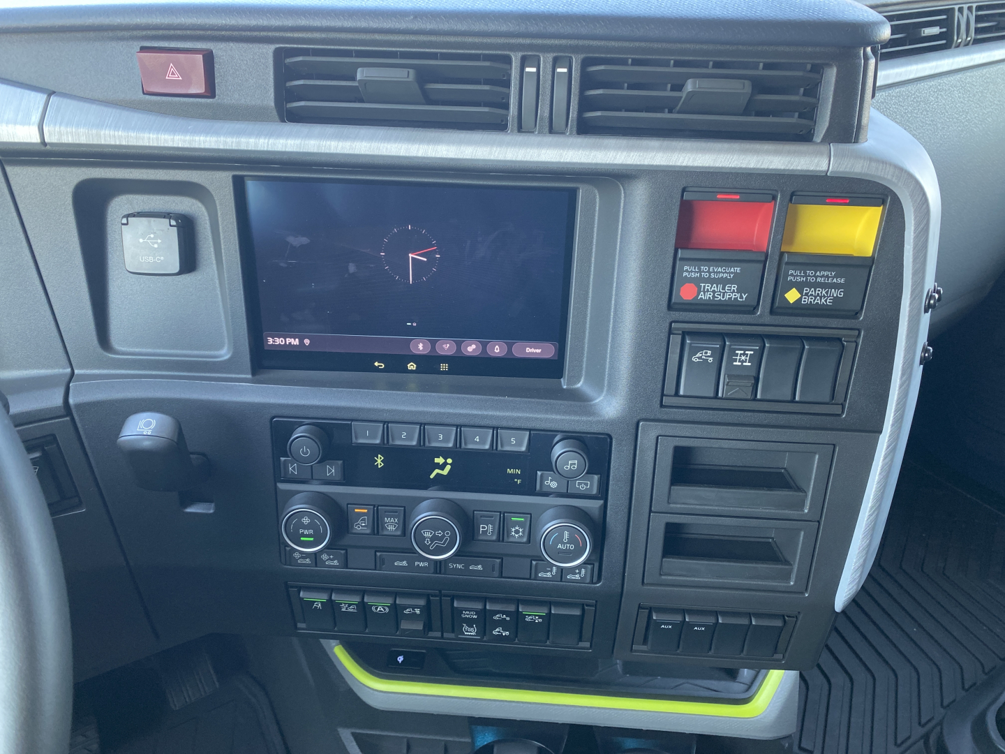 Volvo VNL dash cluster showing touchscreen display and control panels with warning lights and climate controls.