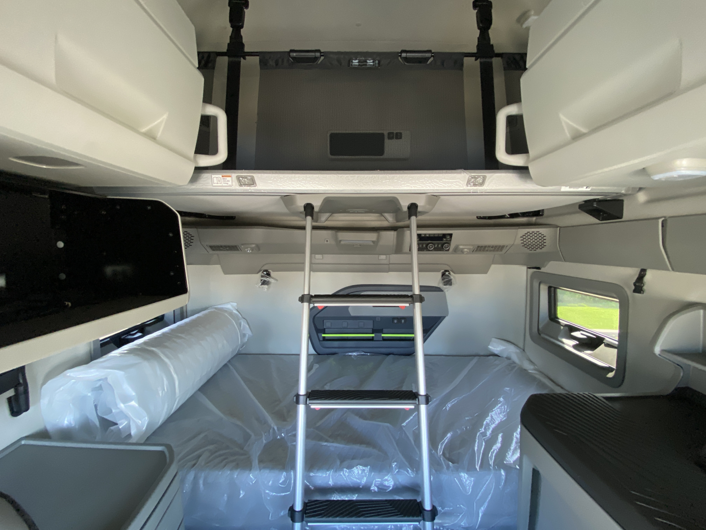 Volvo VNL64T860 truck cabin interior with bunk beds, ladder, and storage compartments visible.
