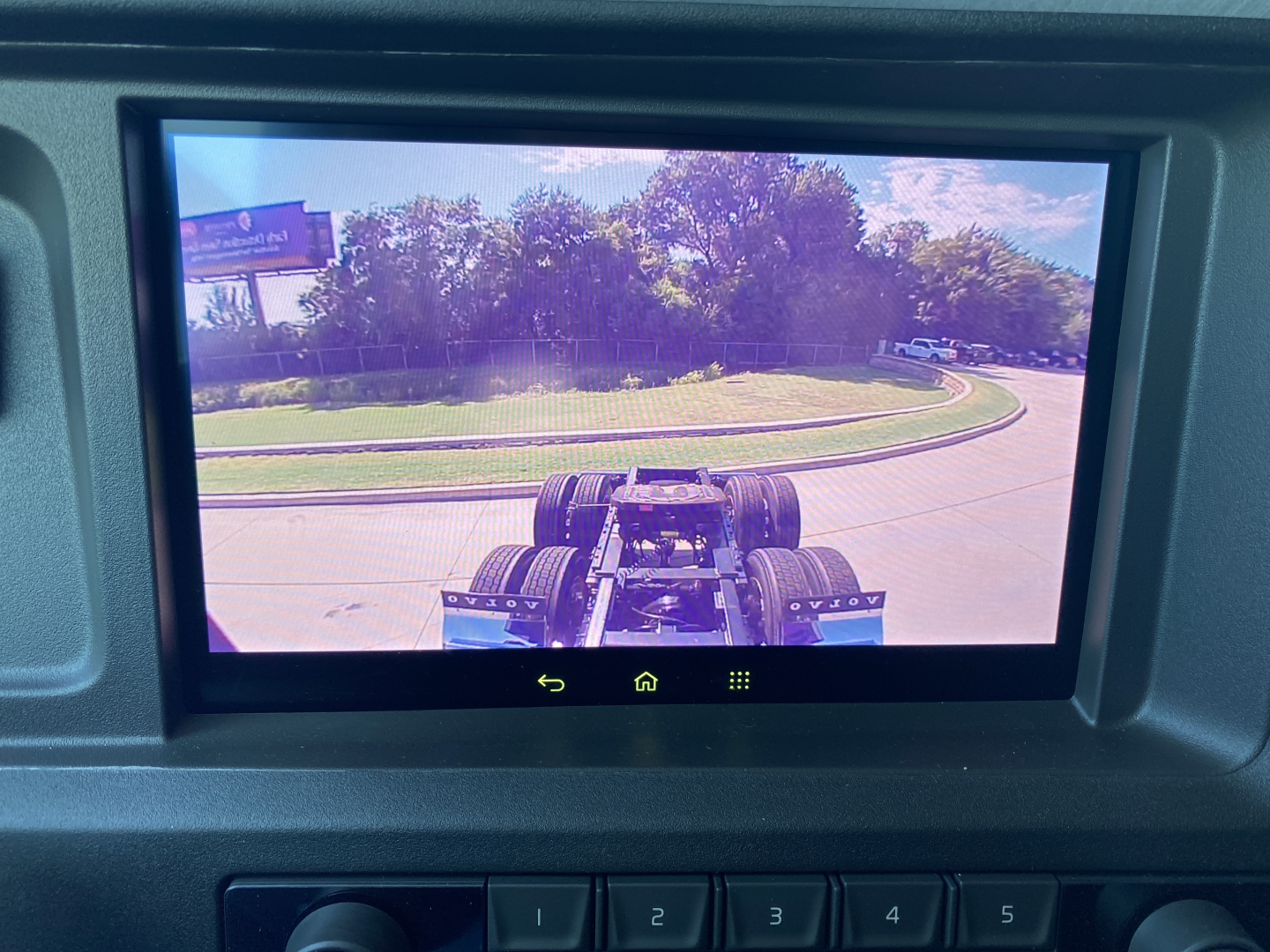 Volvo VNL64T860 dashboard display showing rear view of tractor chassis and axles in camera screen.
