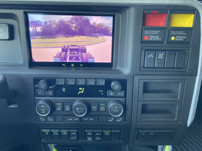Dashboard area of a 2026 Volvo VNL64T860 truck showing a center touchscreen display, control knobs, climate controls, and various warning/light switches.