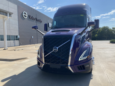 Volvo VNL64T860 truck front view showing prominent grille with chrome accents and Volvo logo, blue exterior, daytime.