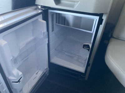 Mini refrigerator/freezer unit in Volvo VNL64T860 cab showing empty freezer compartment and door open.