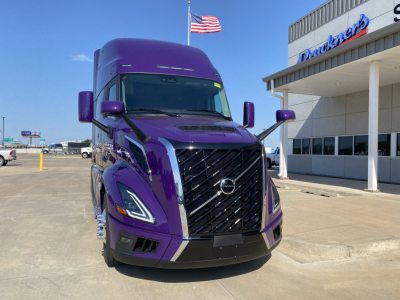 Volvo VNL64T860 truck in purple paint with bold front grille, daytime front view.