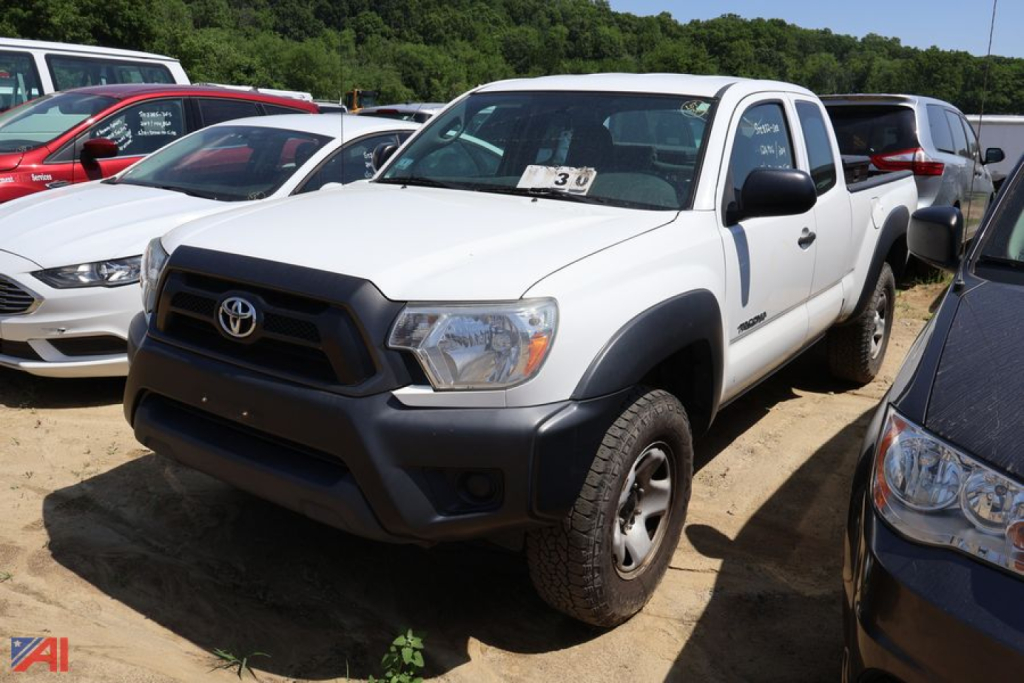 Toyota Tacoma pickup truck 2014 in white with black front bumper and wheel arches, 4x4, single cab, parked in a lot with other vehicles.