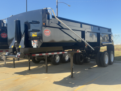 Dump trailer showing a CTS LWED-26 with dual rear axles and landing legs, black exterior, side decals, and safety chains.