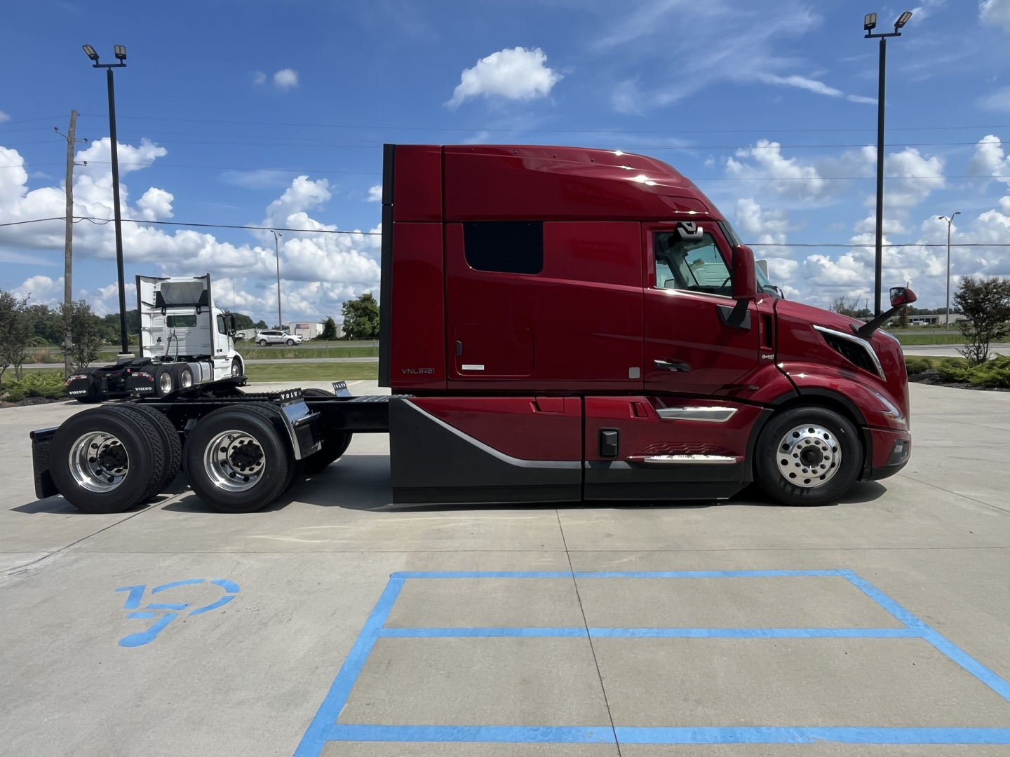 2026 Volvo VNL64T840 conventional sleeper truck side profile showing red cab and dual rear axles.