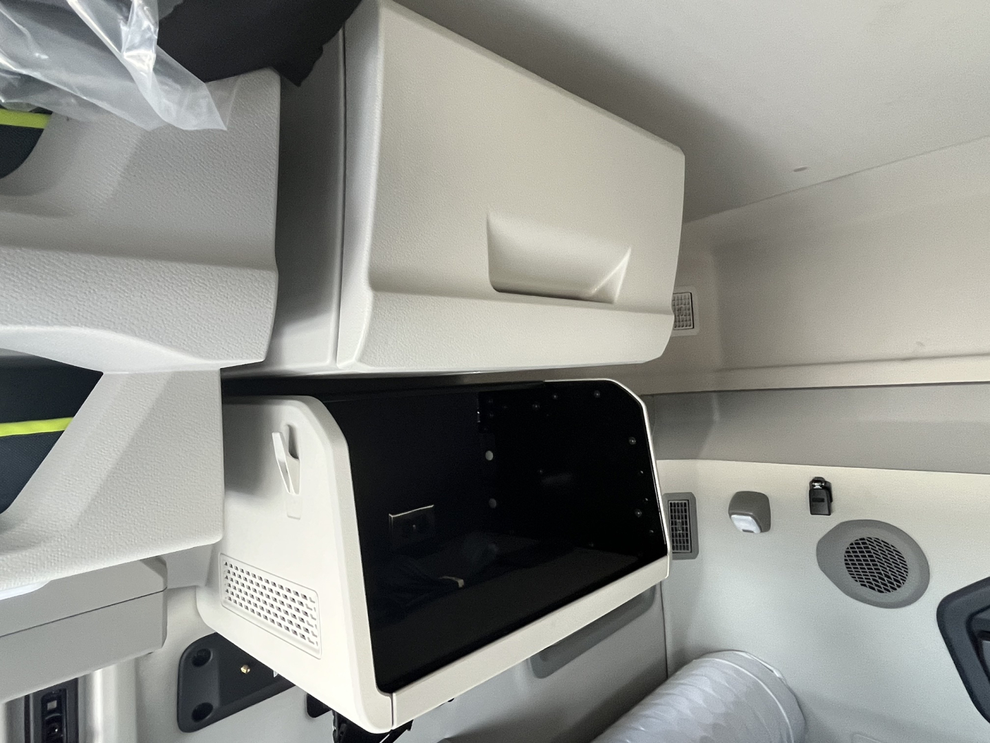 Volvo VNL64T840 cab interior showing sleeper compartment with open storage drawer and control panel area.