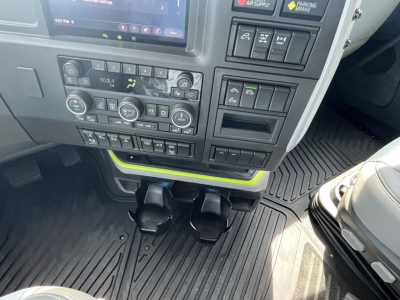 Volvo VNL64T840 dash view showing climate controls, infotainment display, and storage compartments with two cup holders in the center console.