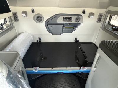 Volvo VNL64T840 sleeper cab interior showing cargo area with black bed platform, storage panels, and control panel on bulkhead.