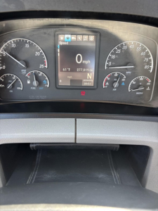 Dashboard of a Freightliner Cascadia 126 showing digital speedometer reading 0 mph, with instrument gauges on left and right including RPM and fuel, and center display.