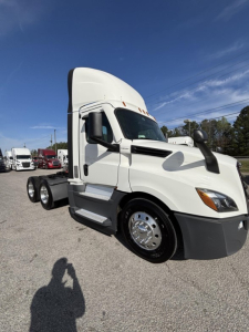 White Freightliner Cascadia 126 day cab truck side view showing sleeper cab, dual rear axles, chrome wheels, daytime running lights, and front bumper.