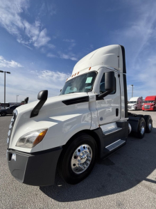 Freightliner Cascadia 126 sleeper cab truck, white exterior, front-left view, chrome wheel covers, side steps, daytime running lights.