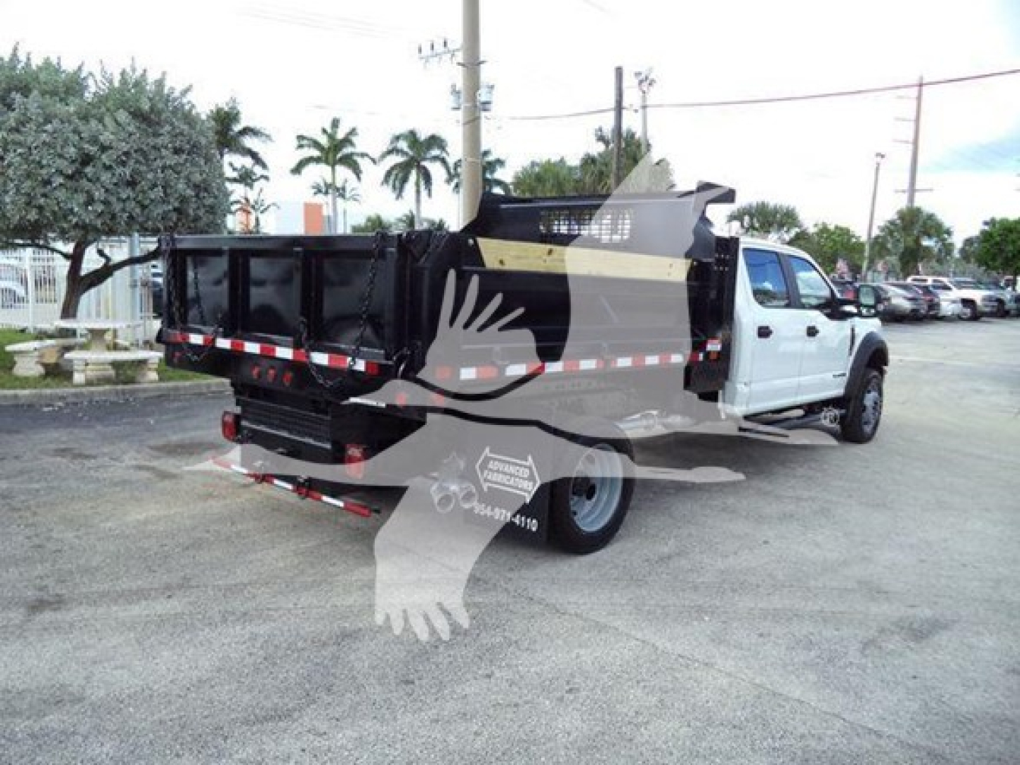Dump truck bed and cab of a 2018 Ford F-550 XLT in-service showing a white cab and black dump body with red/white reflective tape; rear cargo bed visible.