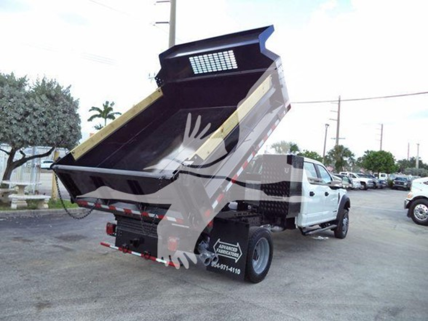 Dump truck bed of a 2018 Ford F550 XL showing raised dump body and rear view with taillights and wheel. Visible side of cab and hydraulic components.