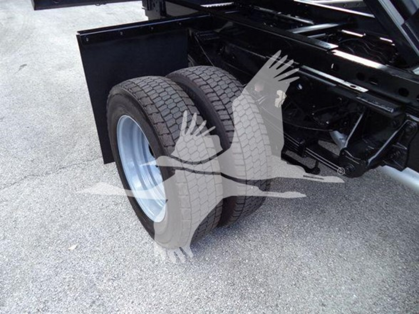 Dual rear tires on a Ford F-550 chassis showing wheel assembly and frame near the dump bed.