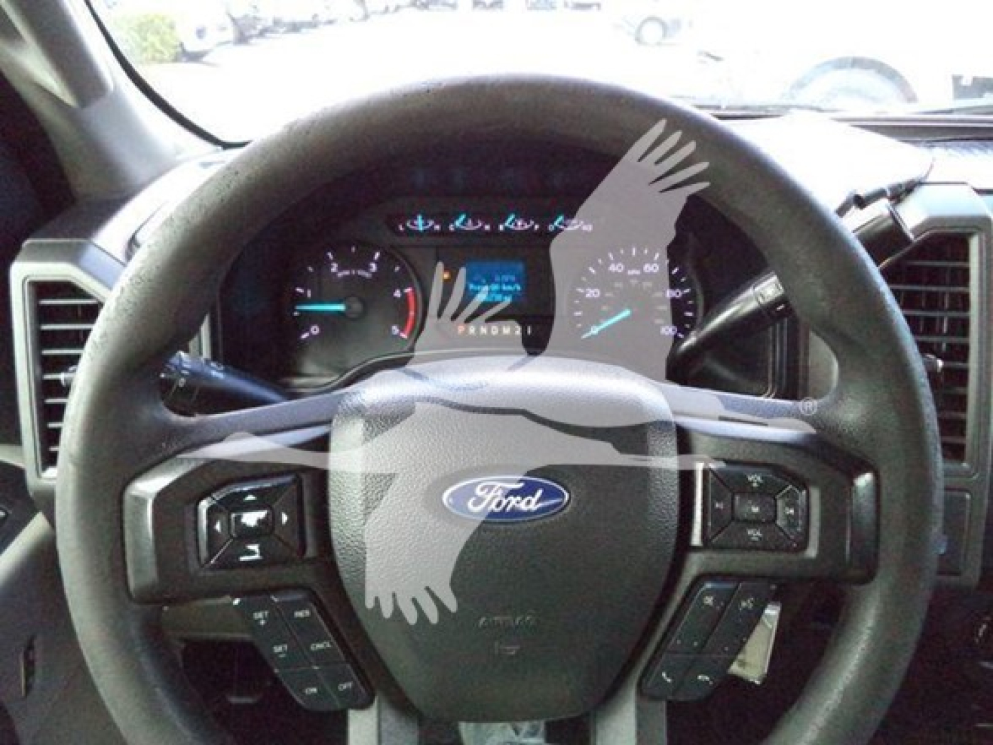Ford steering wheel and instrument cluster in the cab of a 2018 Ford F-550 XL dump truck showing steering wheel controls and dashboard gauges.