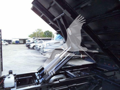 Ford F-550 engine bay with raised dump bed showing engine components and hoses
