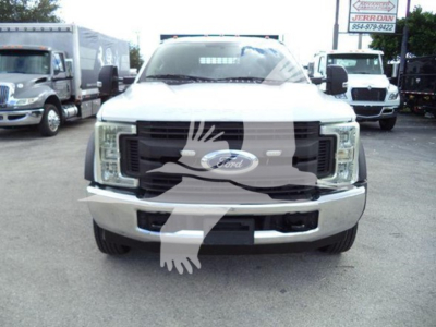Ford F-550 front view showing grille with Ford emblem and bumper, in-service white truck.