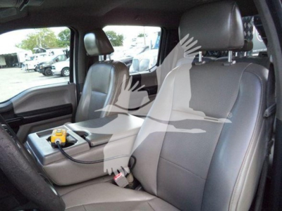 Ford F-550 interior front seats with center console and electrical tester on armrest.
