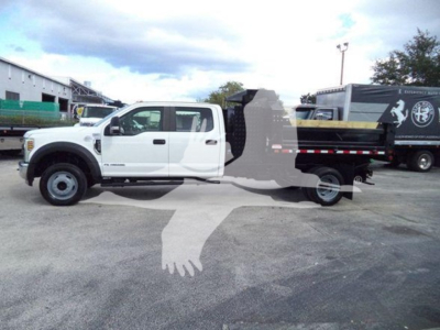 White Ford F-550 XL dump truck side view with extended cab and black dump bed. Overlayed watermark silhouette of a handshake logo in the middle.