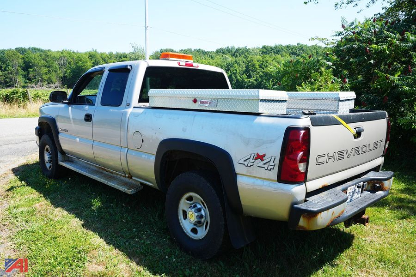Chevrolet 2500HD Silverado pickup truck rear-left view showing 4x4 badge and tailgate with Chevrolet lettering, in-service cargo bed toolbox.