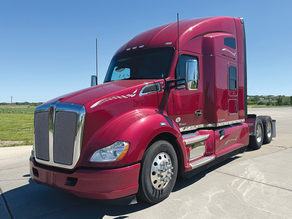 Kenworth T680 tractor in red viewed from front-left showing aerodynamic hood and grille.