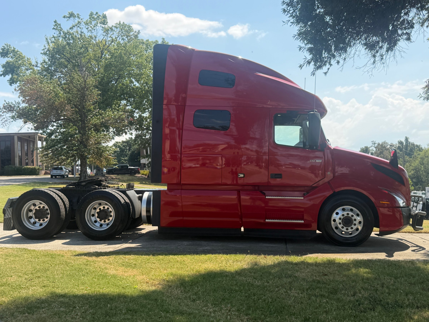 Volvo VNL64T760 sleeper tractor in red side view showing cab, windows, and rear dual axles.