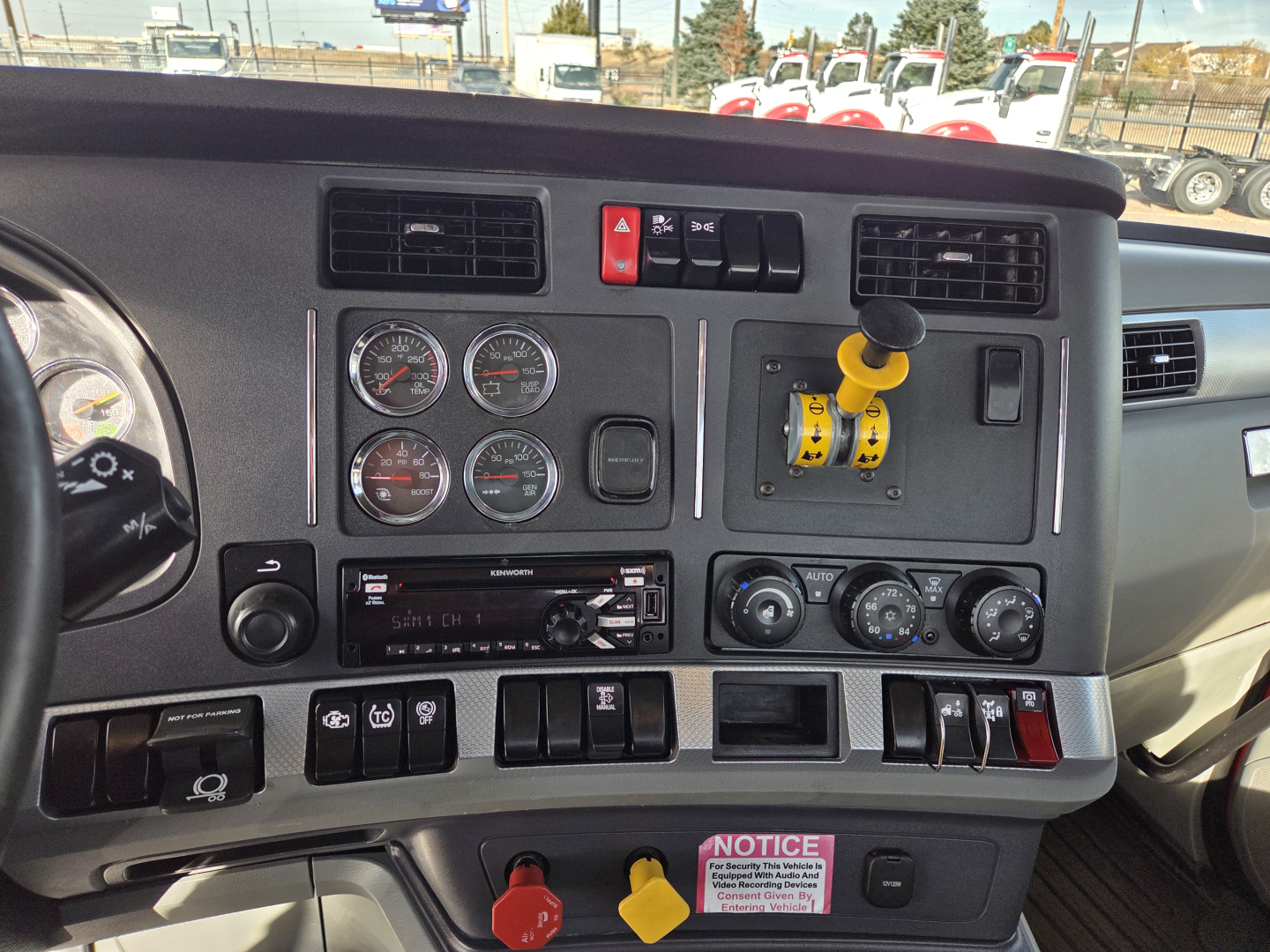 Dashboard of a 2020 Kenworth T880 showing multiple gauges, ignition switches, yellow safety lever, and control dials in driver cockpit.